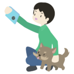 スマートフォンで愛犬と写真を撮影する飼い主